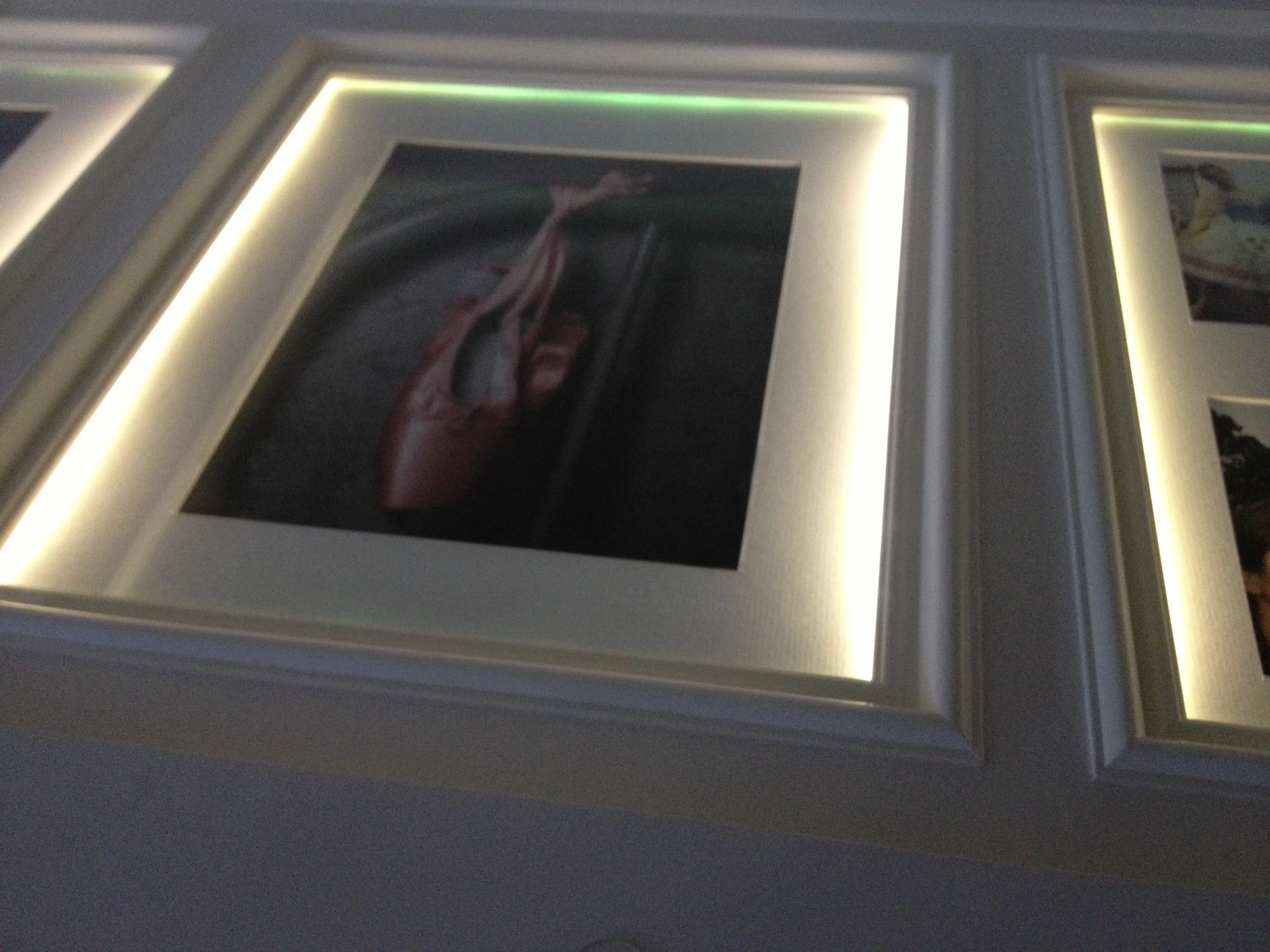 Close view of illuminated photographs beneath the desk surface