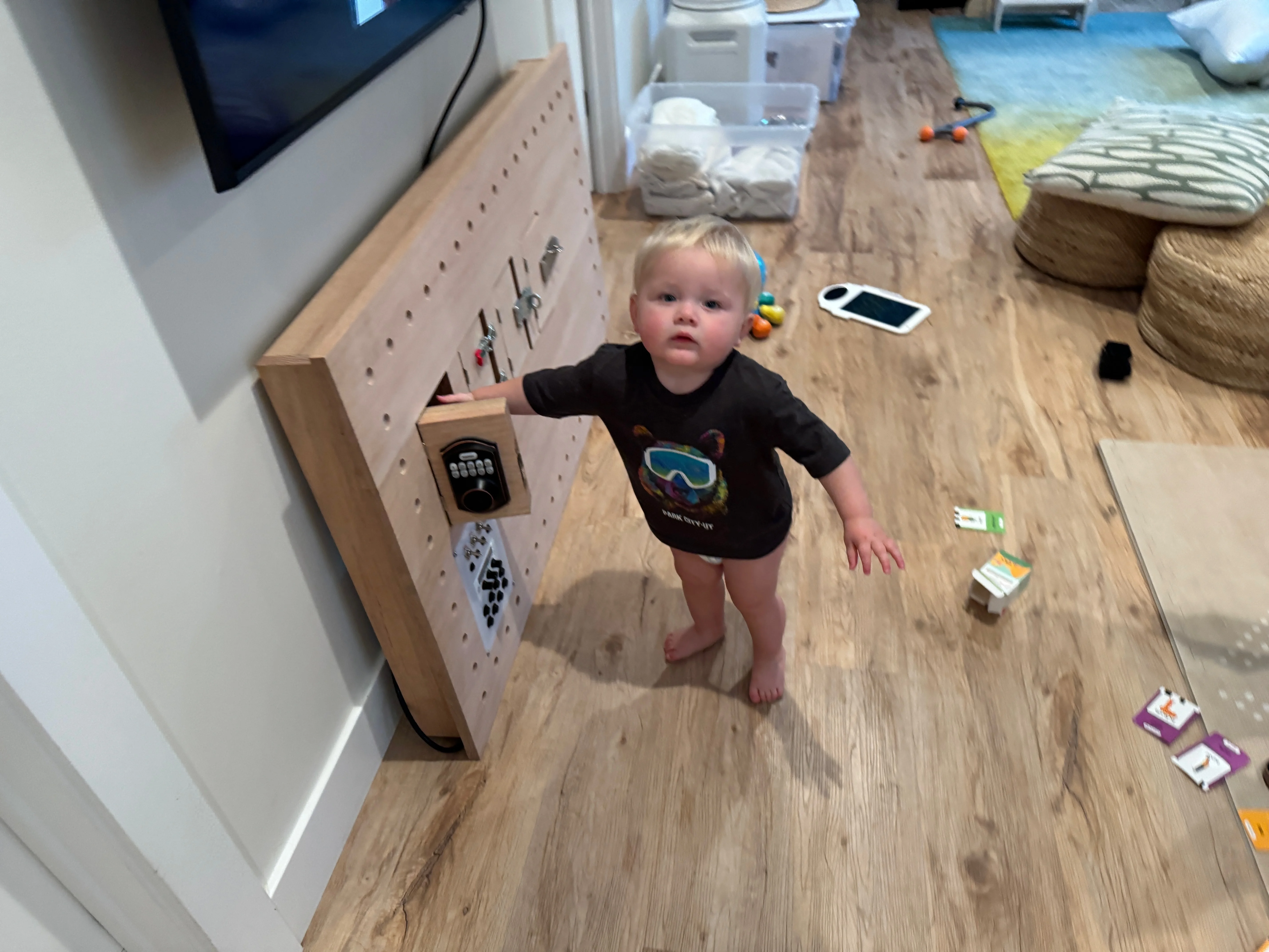 Young child standing beside the installed busy board