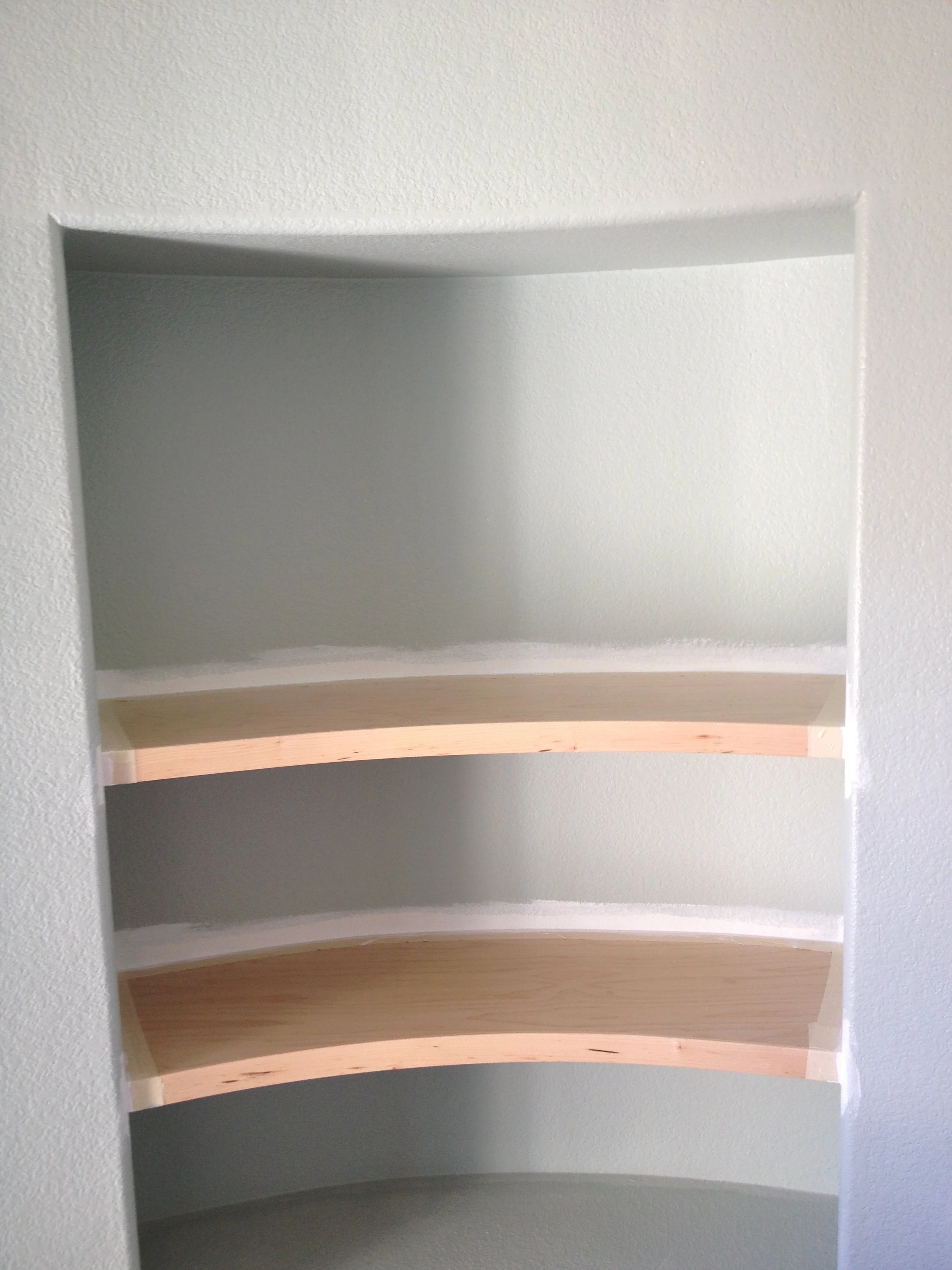 Finished fitted shelves following a curved wall
