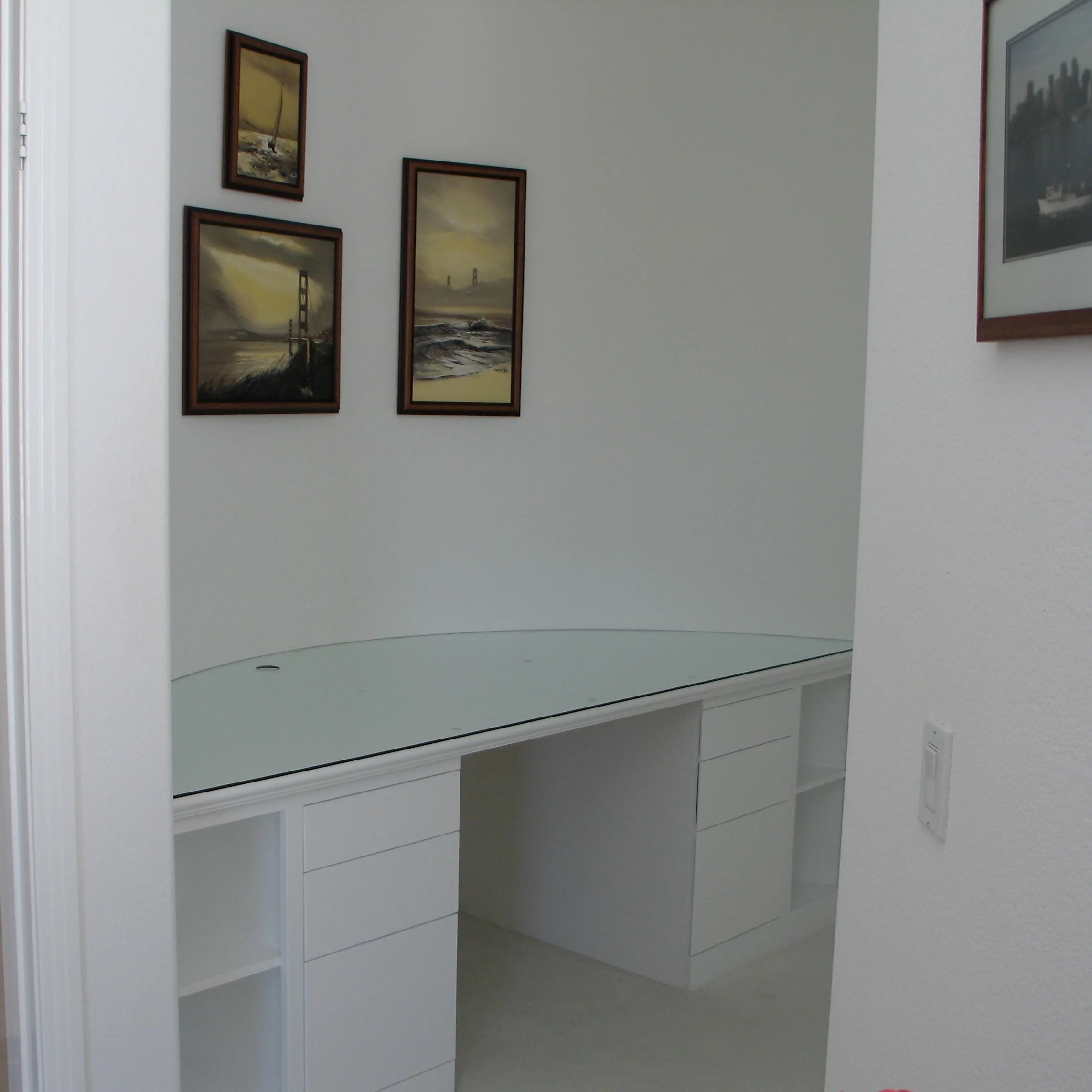 Long white built-in desk with glass work surface