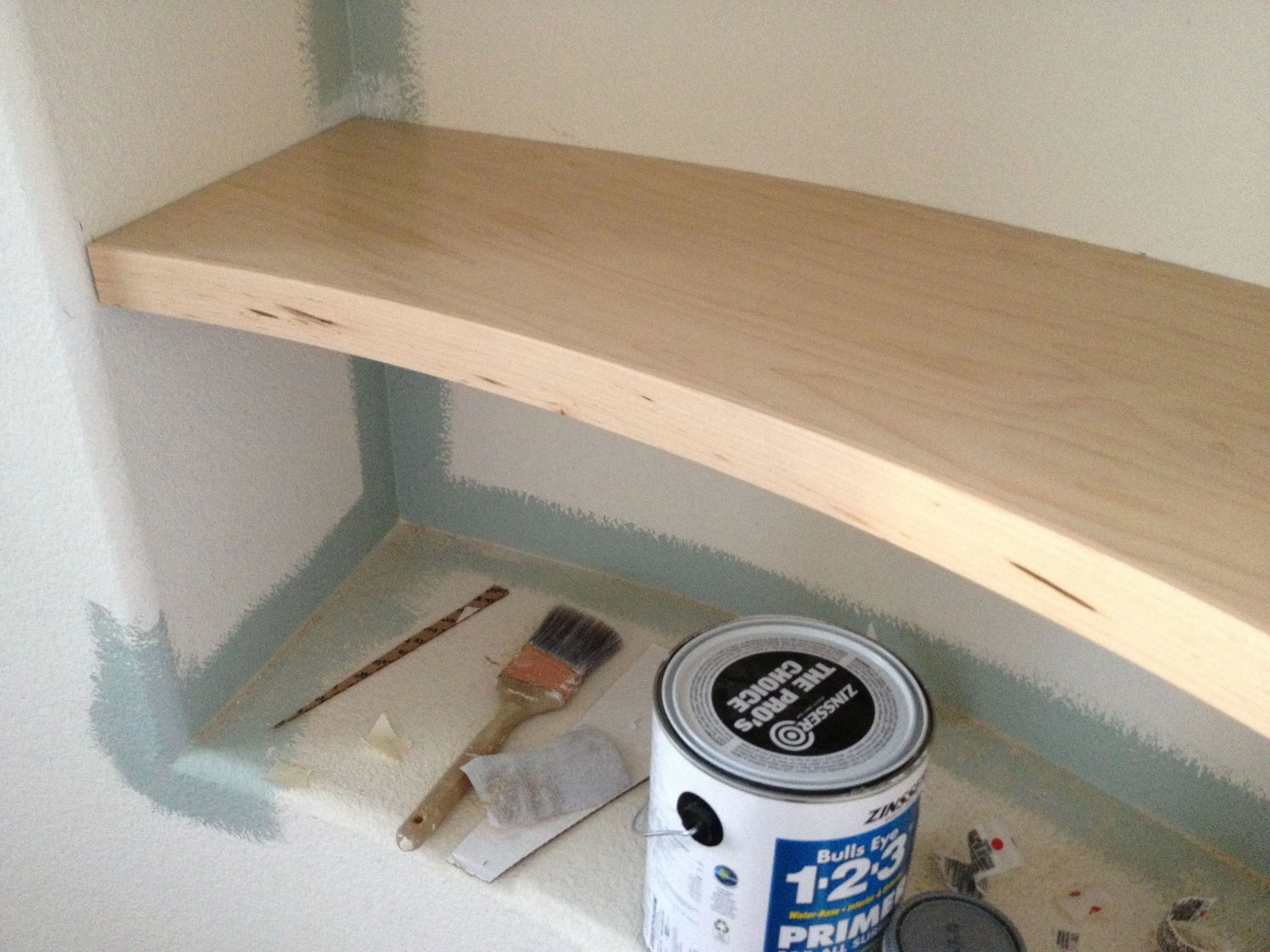 Wood shelf being fitted into the curved wall opening